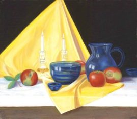 Apples sitting on a yellow cloth with blue pitcher and blue bowl